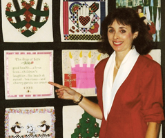 Photo of Carolyn Fostel pointing to her quilt square on North Shore University Hospital's 35th Anniversary Celebrate Life quilt project. Photo of Carolyn Fostel pointing to her quilt square on North Shore University Hospital's 35th Anniversary Celebrate Life quilt project.